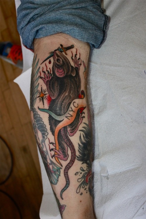Interesting colorful rodent with knife in teeth and ribboned lettering tattoo on arm