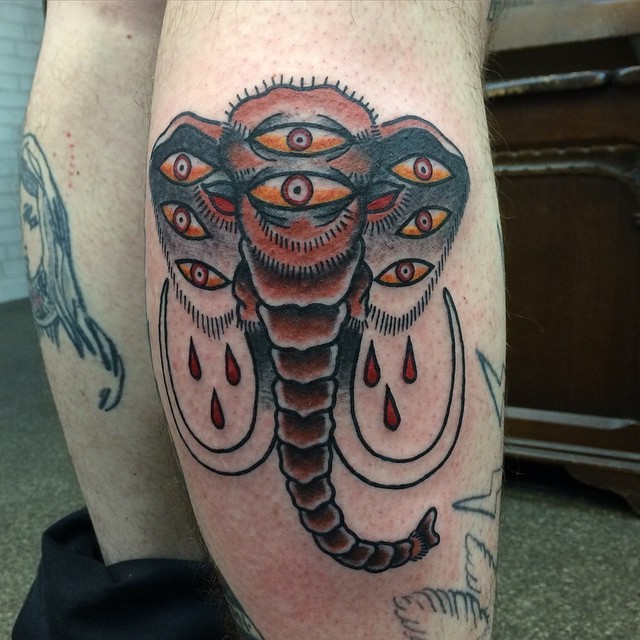 Tattoo von interessant gestaltetem abschreckendem Mammut mit vielen Augen im altschulischen Stil an der Wade