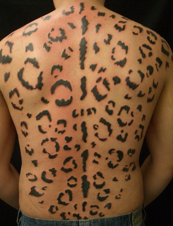 Large black-ink cheetah print tattoo on back
