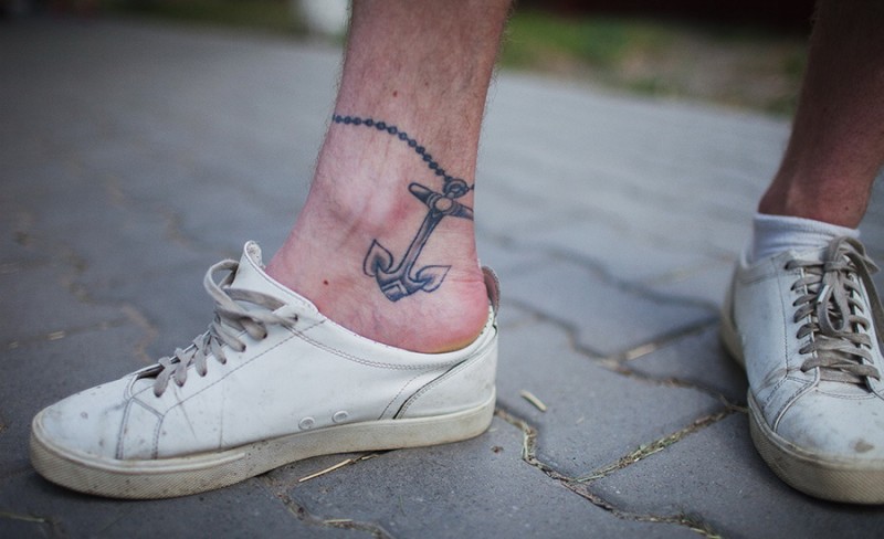 Little black-and-white anchor on chain tattoo on shin