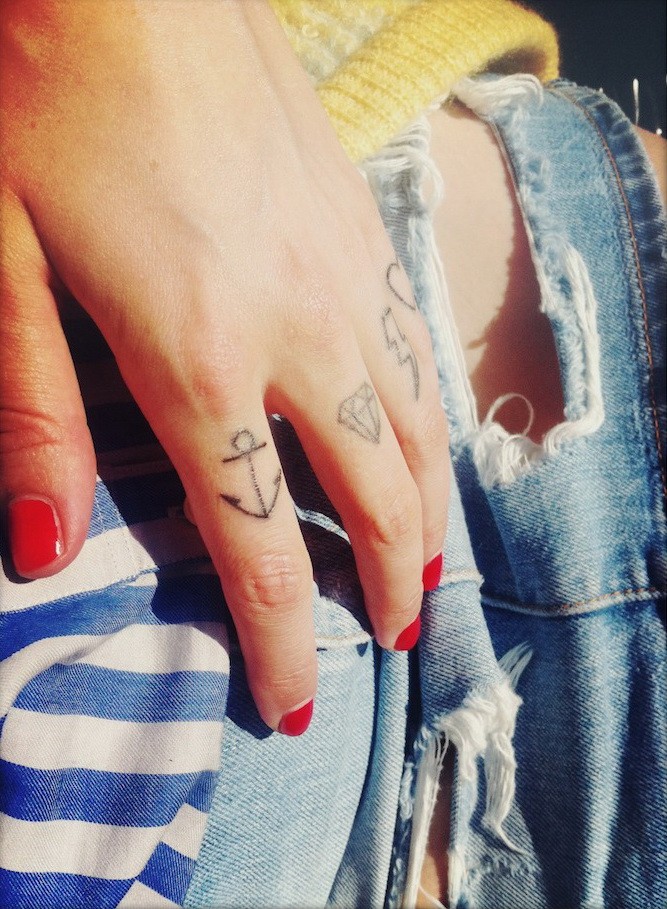 Kleines schwarzes Anker-Tattoo am Zeigefinger