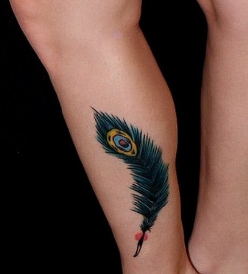 Little turquoise-colored peacock feather tattoo on shin