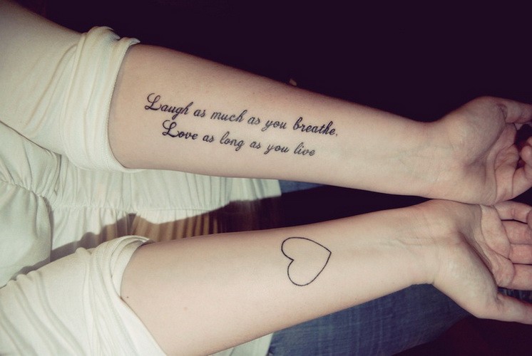 Lovely black-and-white quote and a heart tattoo on arm