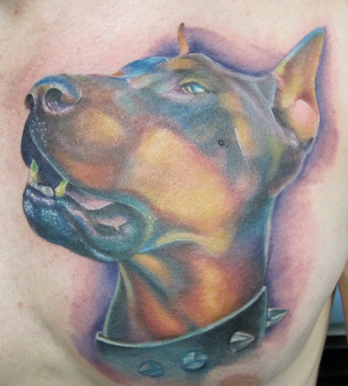 Tattoo vom Dobermannkopf mit Stachelhalsband in ungewöhnlichen Farben an der Seite