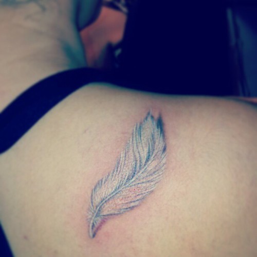 Lovely fuzzy white feather tattoo on shoulder