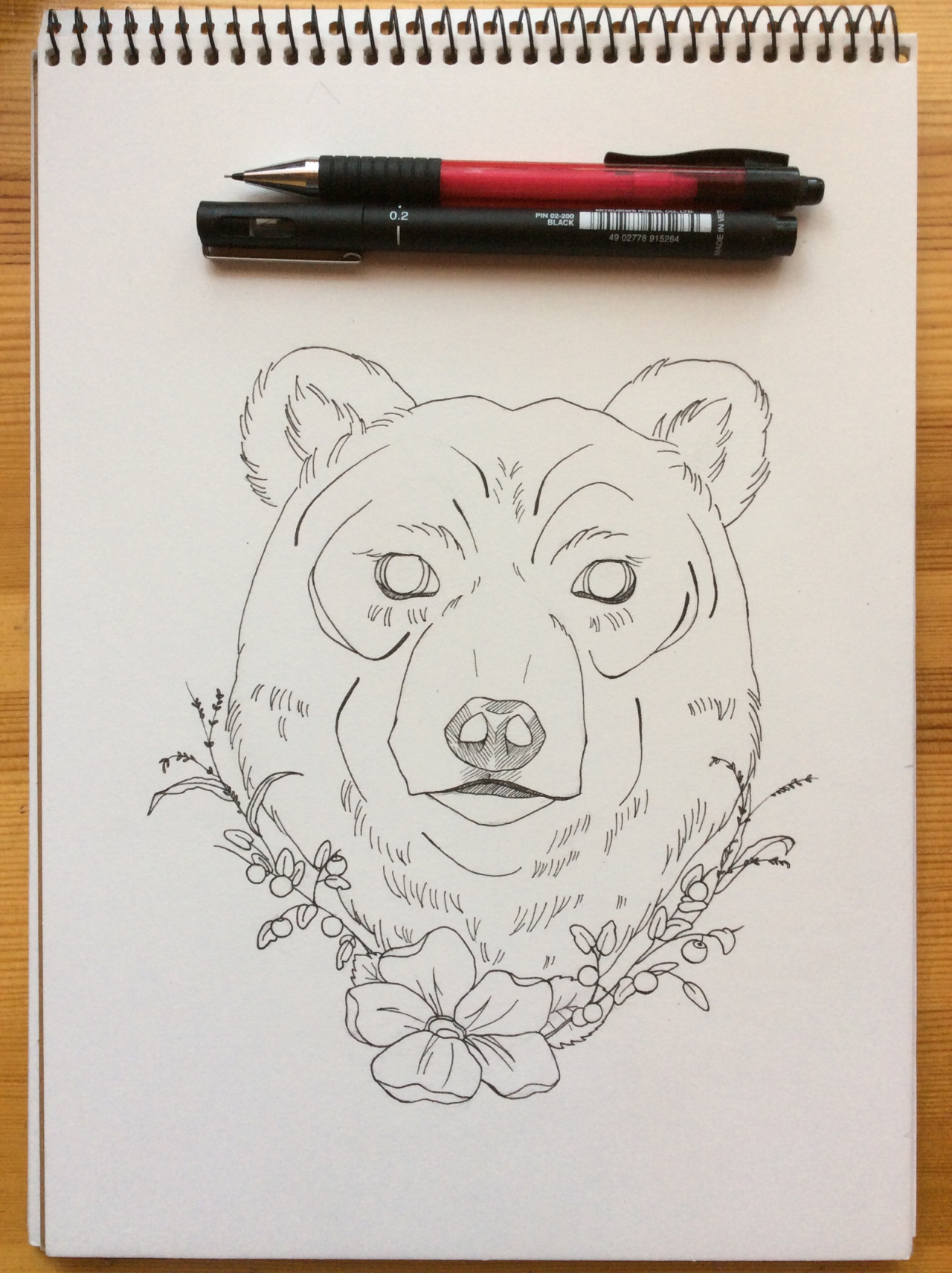 Lovely uncolored bear head with floral frame tattoo design