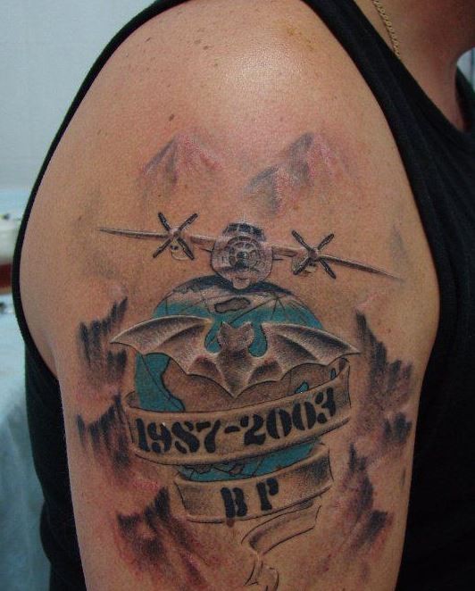 Military memorial style colored upper arm tattoo of big plane with lettering