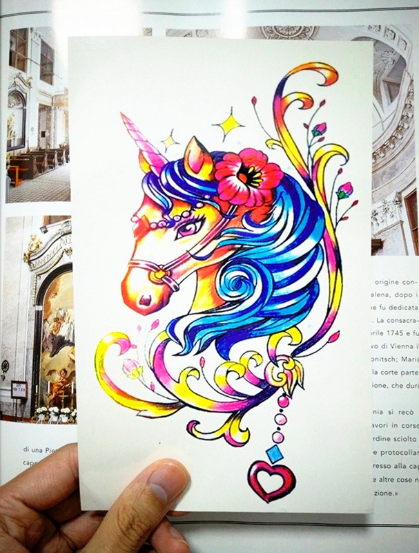 Montly rainbow-colored unicorn portrait with curly decorations tattoo design