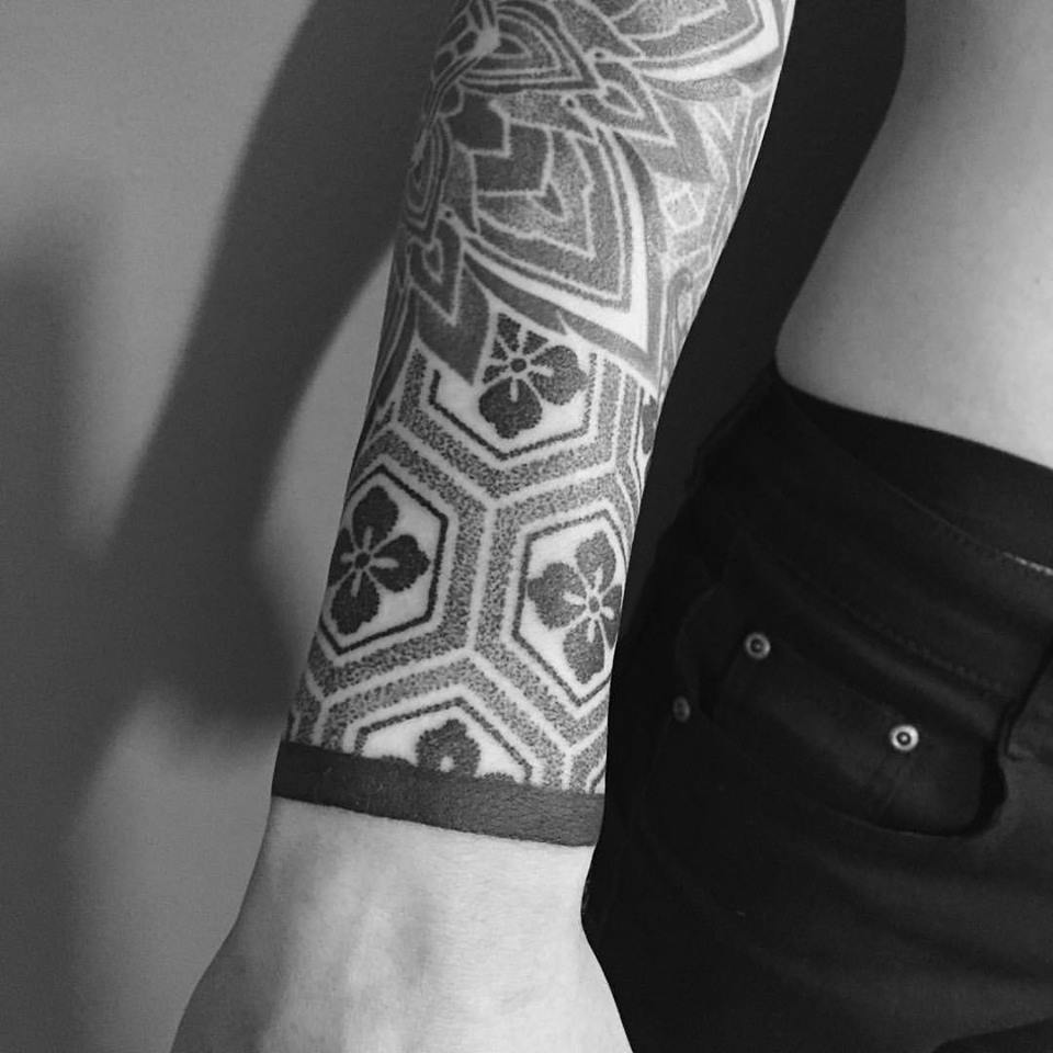 Bela tatuagem com padrões geométricos no antebraço