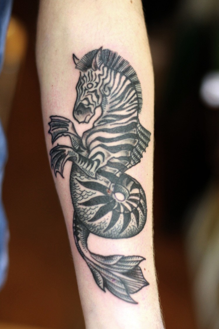 Tatuaje en el antebrazo,
cebra extraordinaria con la cola de pez