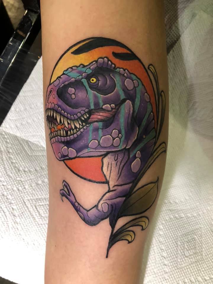 Purple dinosaur tattoo on leg