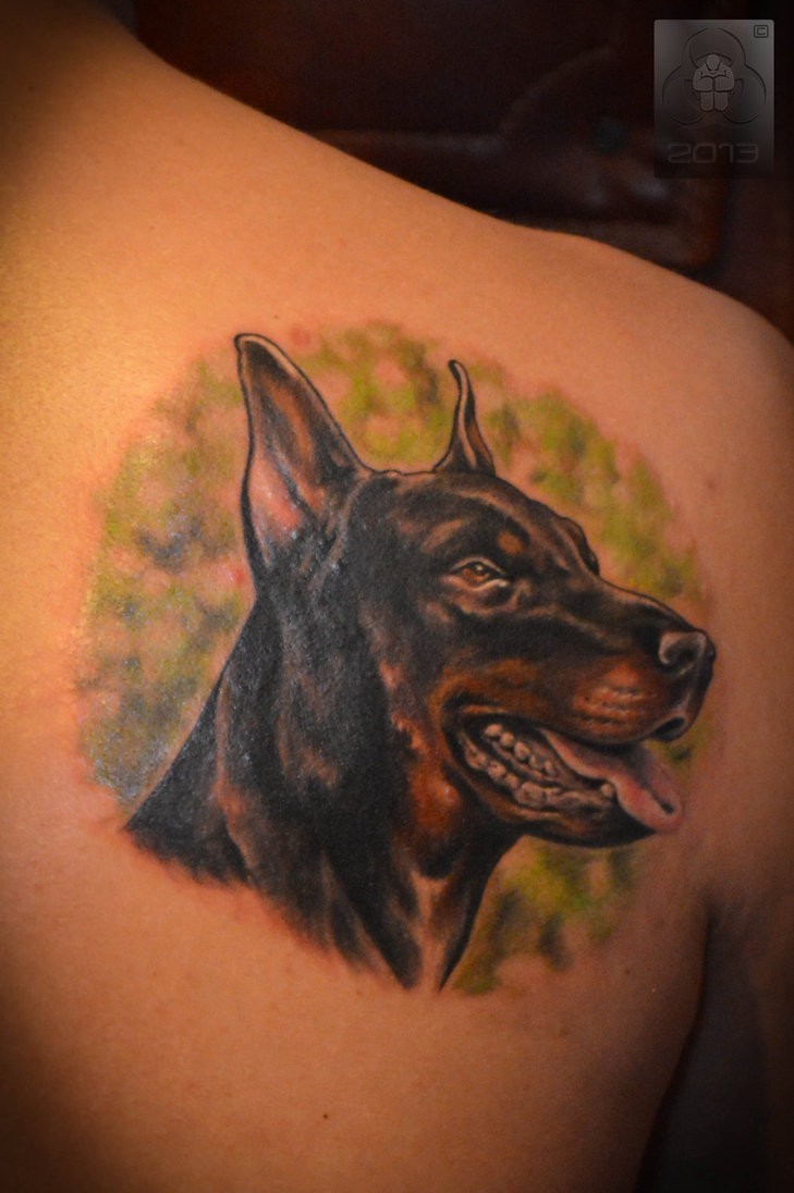 Rücken Tattoo mit realistischem Dobermannkopf auf grünem Hintergrund