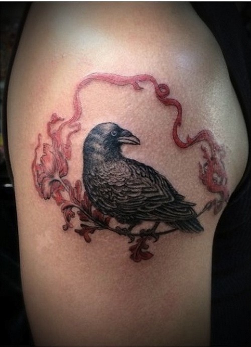 Realistic raven sitting on flower with red ribbon tattoo on upper arm