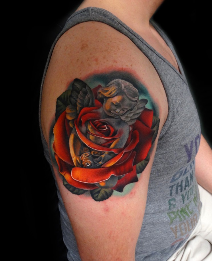 Realistic red rose and cherub tattoo on shoulder