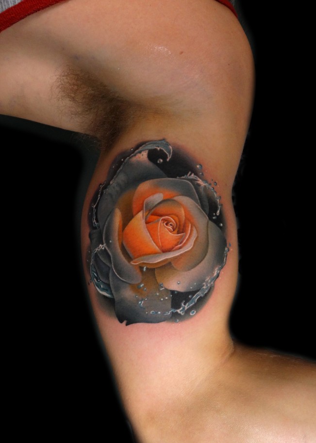 Realistic rose tattoo on biceps
