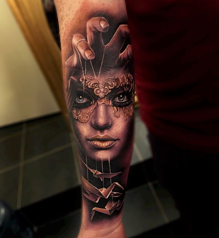 Realistic woman in mask and origami tattoo