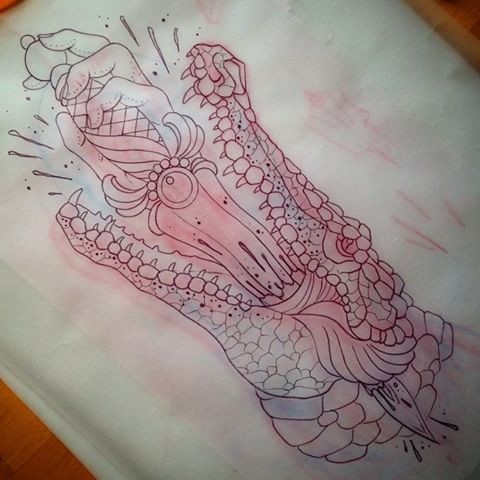 Red-shining reptile head killed with sword tattoo design