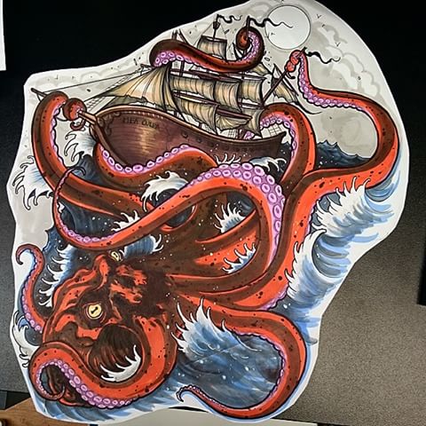 Red furious octopus crashing a pirate ship tattoo design