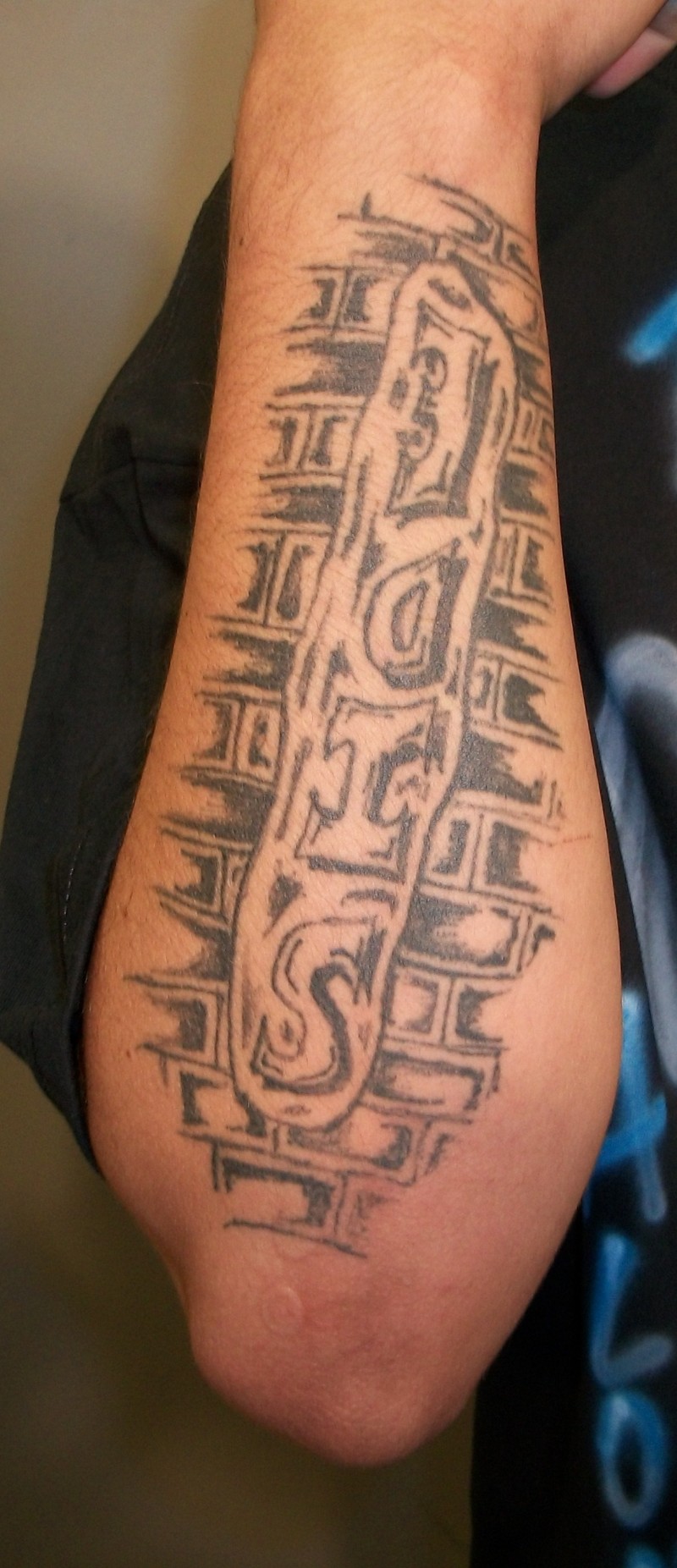 Tattoo von umgedrehtem Wort &quotSide" mit Ziegelwand im  Hintergrund am rechten Unterarm von Roberto Avina Castillas