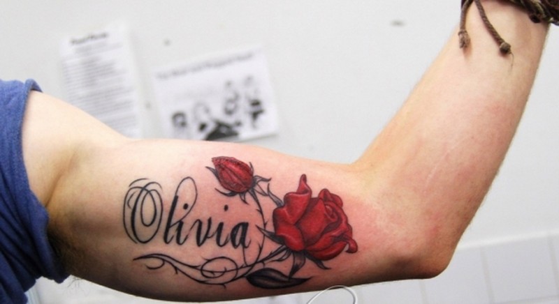 Romantic Olivia name quote with rose tattoo on arm