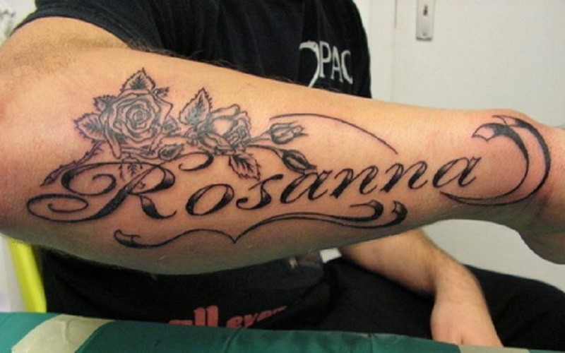 Romantisches schwarzweißes Namenstattoo mit Rosen am Arm
