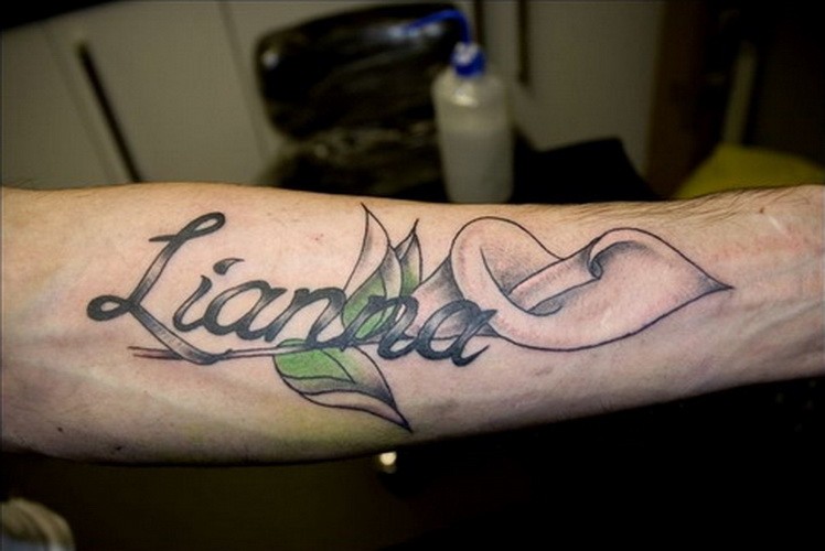Romantic girlfriend name quote with lily tattoo on arm