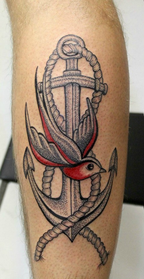 Tatuaje de ancla con ave hermosa en la espinilla