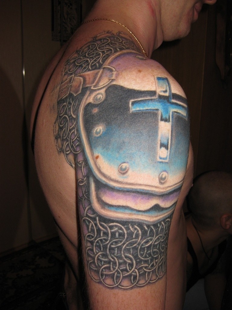 Tatuaje de armadura con cruz en el hombro