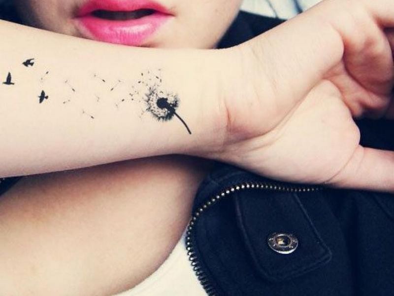 Simple black-and-white dandelion flower tattooom arm