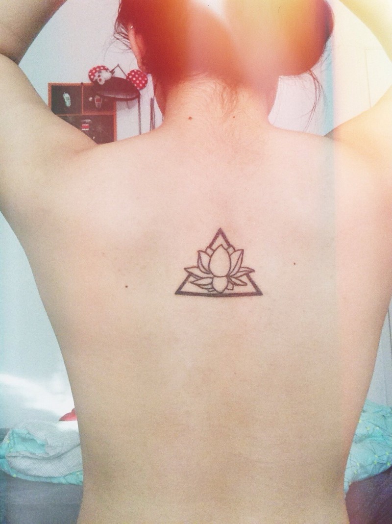 Simple black-ink lotus flower in triangle tattoo on back