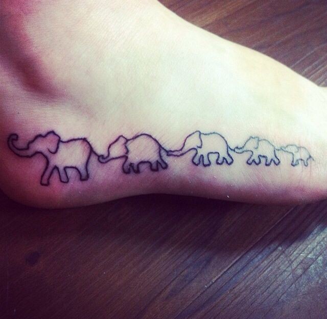 Simple black contoured elephant family tattoo on foot