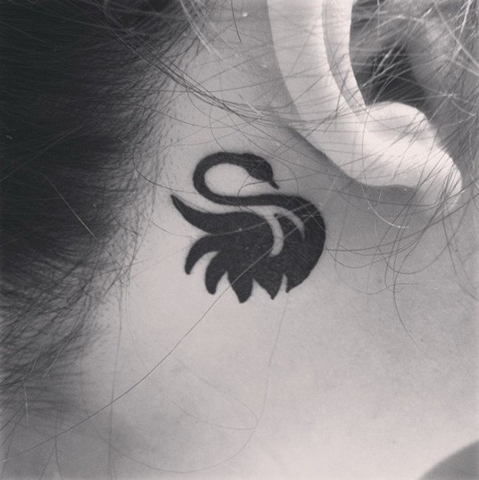 Simple black swan tattoo for girls behind ear