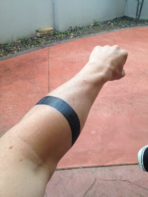 Simple thick-line black-ink band tattoo on forearm