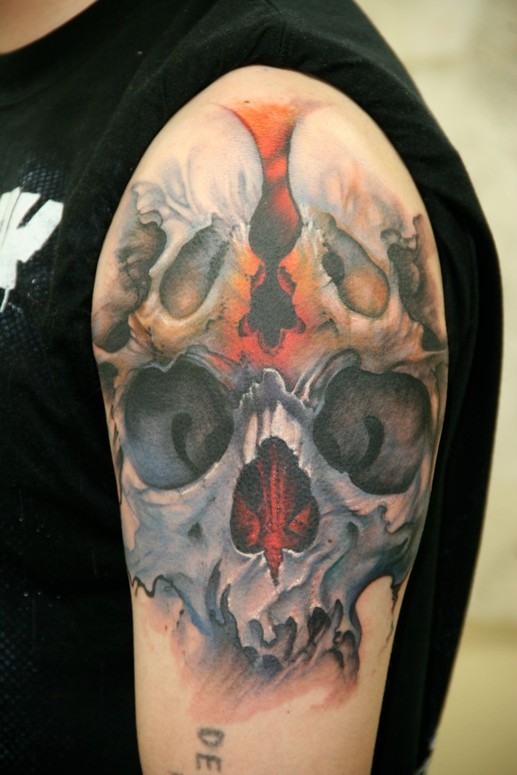 Skull collage tattoo on shoulder for men