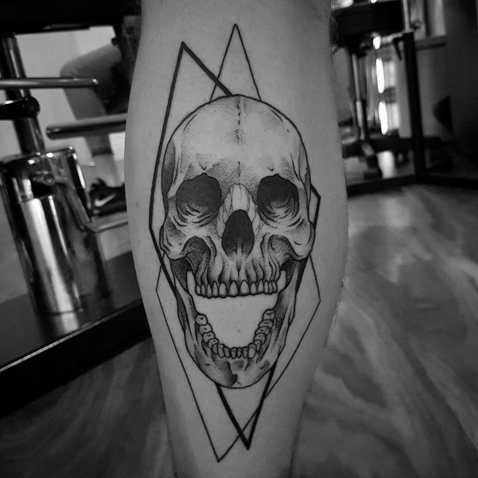 Skull with open jaw tattoo on leg