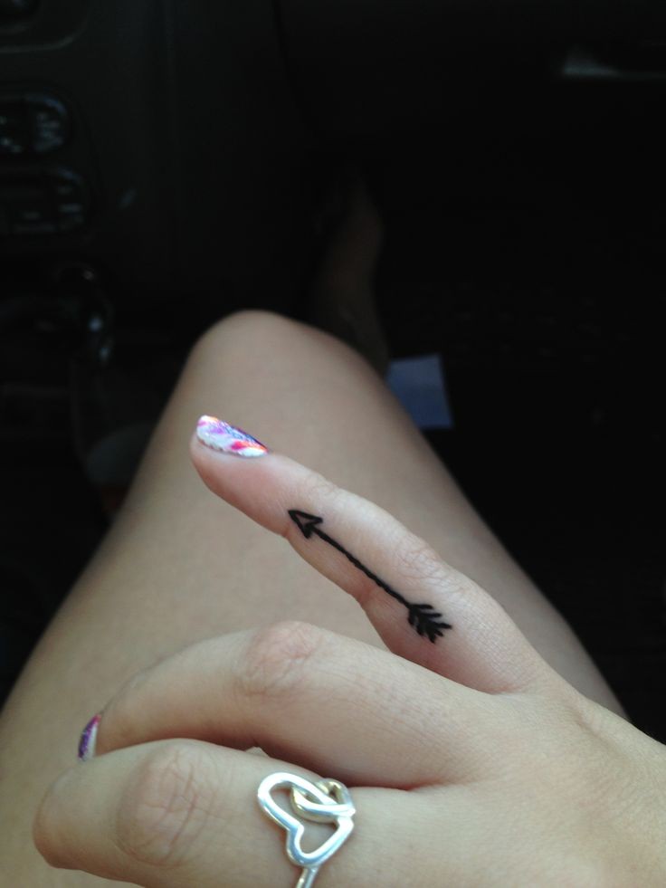 Tatuaje en el dedo, flecha simple de tinta negra