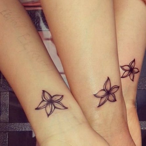 Small black-contour jasmine flower tattoos on wrist