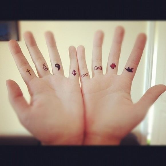 Small colorful symbol tattoos on fingers