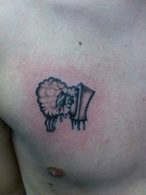 Small simple black-ink sheep watching TV tattoo on chest