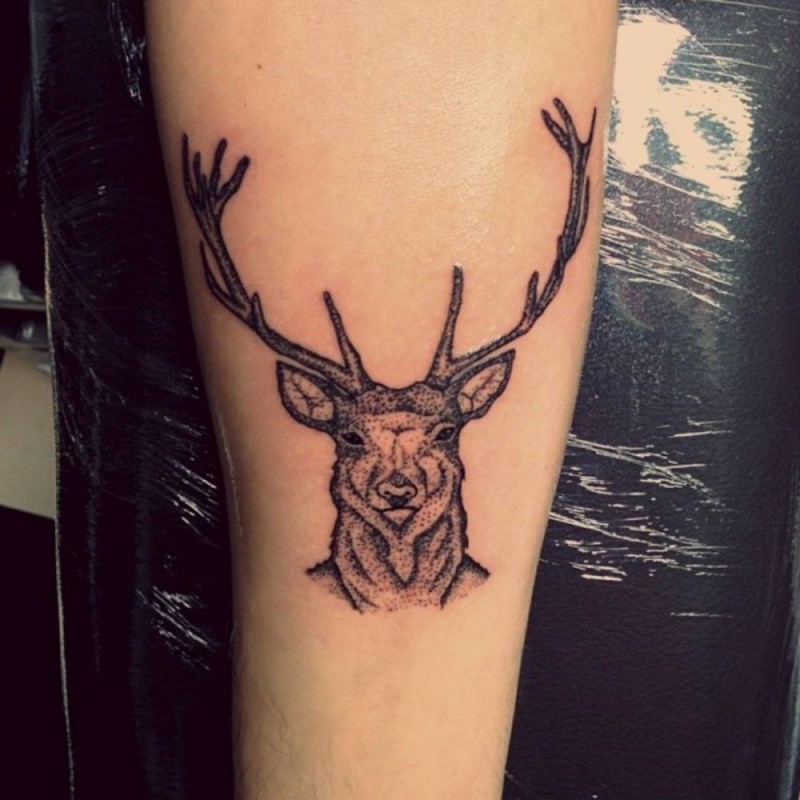 Small traditional black-ink deer tattoo on forearm