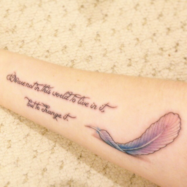 Tender curly-lettered quote with pink feather tattoo on arm