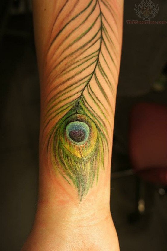 Thin green-colored peacock feather tattoo on arm