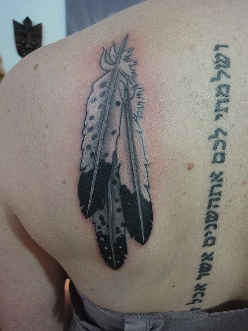 Three large white eagle feathers tattoo on back