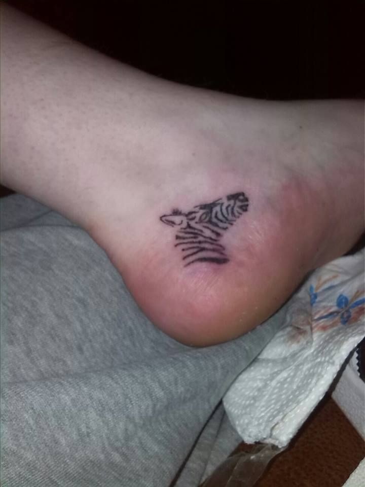 Winziger Zebrakopf mit schwarzer Kontur  Tattoo am Fuß