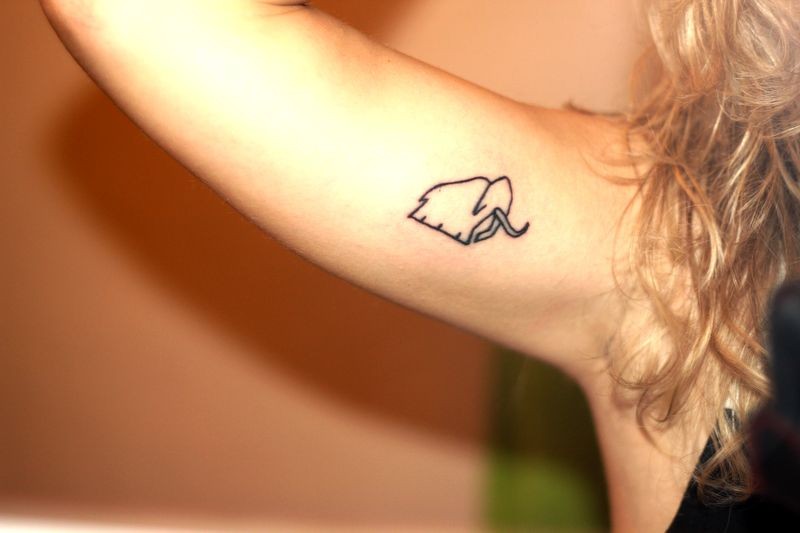 Tiny cute girly mammoth tattoo on upper arm