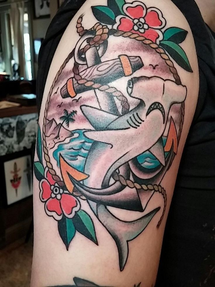 Tatuaje en el brazo,
tiburones martillo, ancla y mar