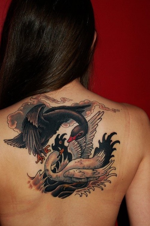Tragical fighting black and white swans tattoo on upper back