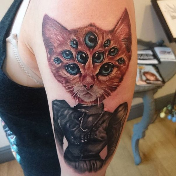 New school style colored shoulder tattoo of cat with multiple eyes