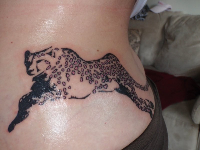 Unusual black-ink running cheetah with pink spots tattoo on side