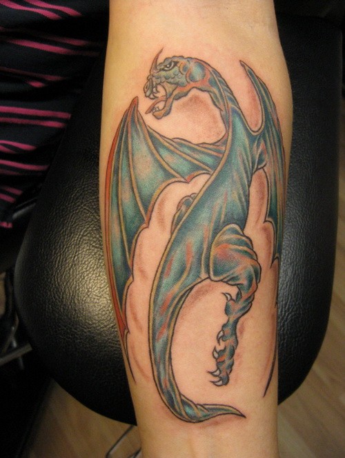 Unusual blue-colored dragon tattoo on forearm